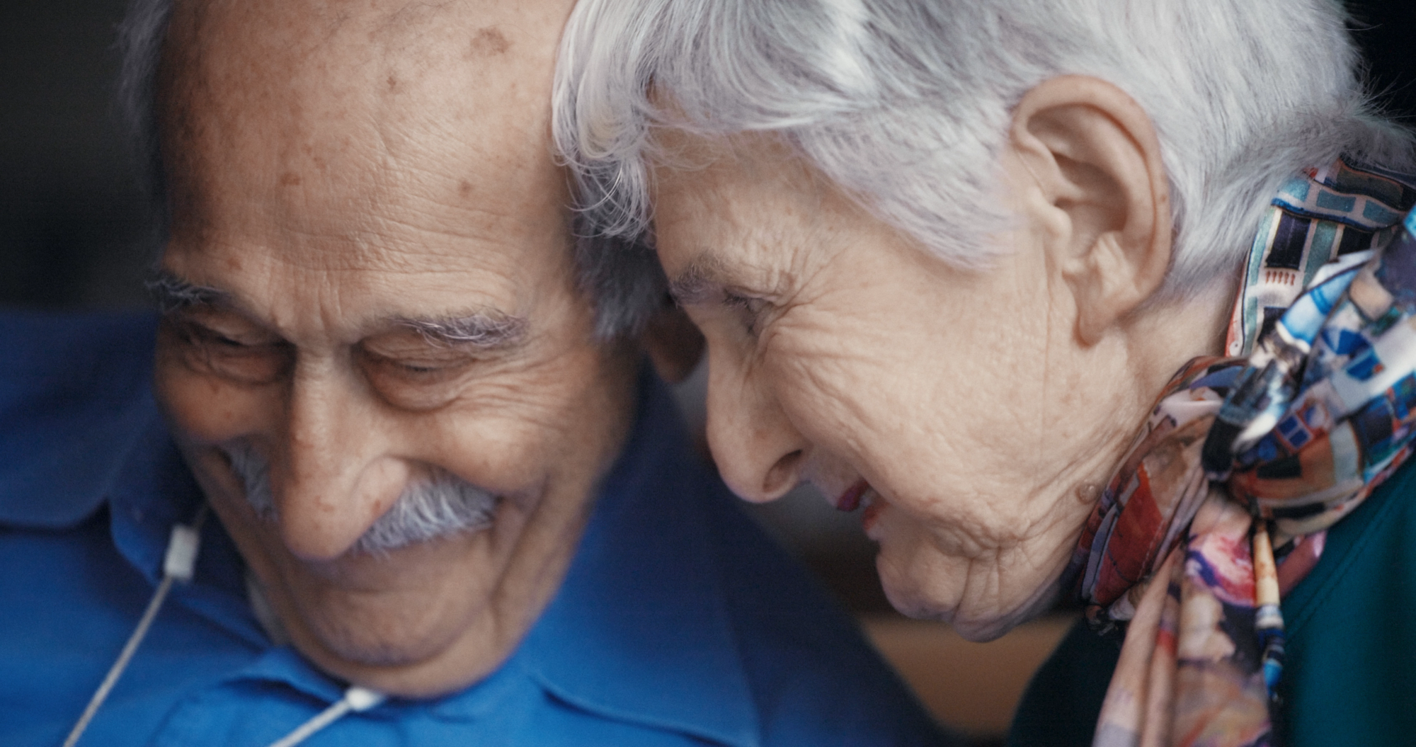 burt and ethelle lean their heads together in a close-up from love, rendered