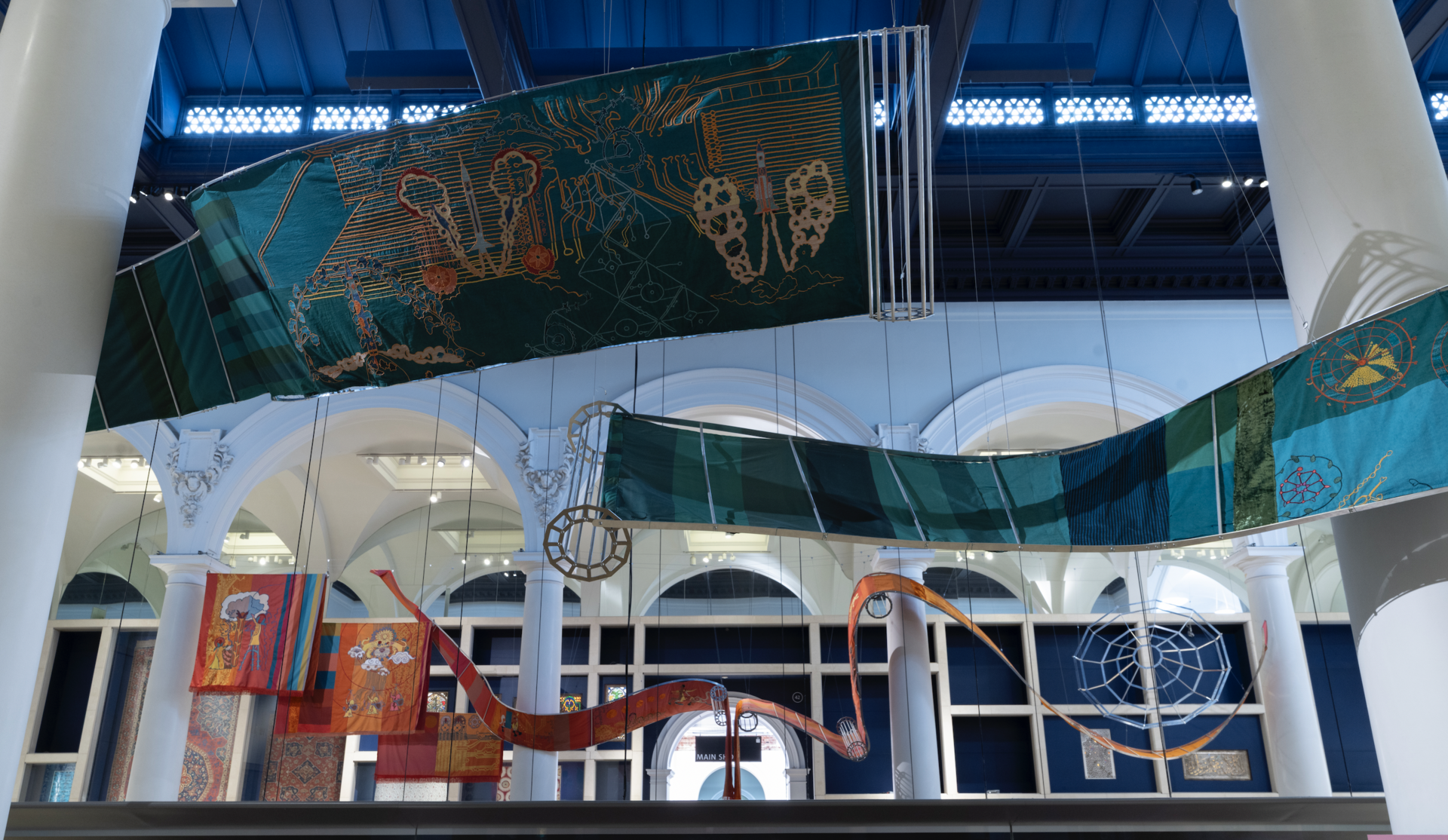 Suspended embroidered textile ribbons in the gallery; actual installation photograph
